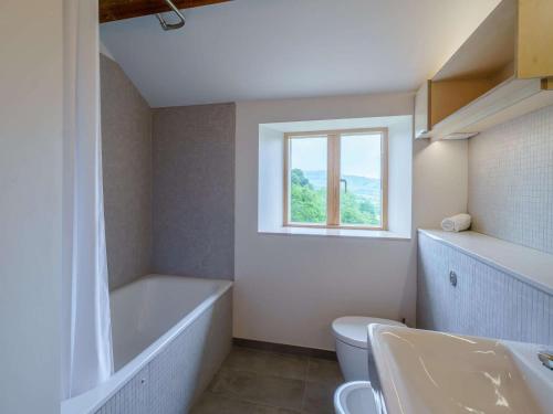 a bathroom with a tub and a toilet and a window at 3 bed in Matterdale 83002 in Dockray