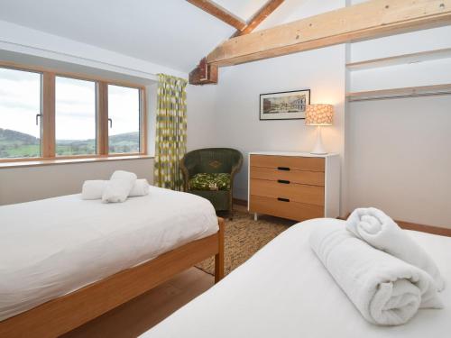 a bedroom with two beds and a chair at 3 bed in Matterdale 83002 in Dockray