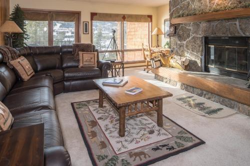 a living room with a leather couch and a fireplace at Skycrest 1714 in Big Sky