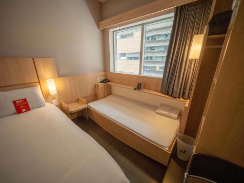 a small room with two beds and a window at ibis Medellin in Medellín