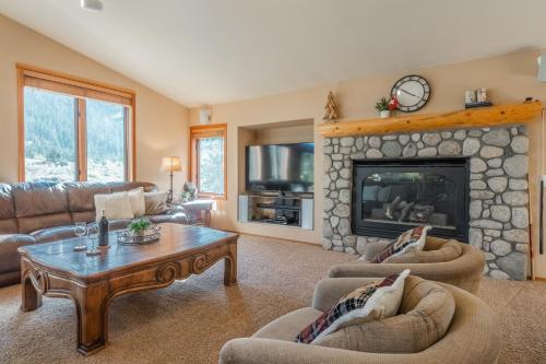 a living room with a stone fireplace with couches and a table at Snowcreek V 756 in Mammoth Lakes