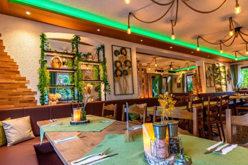a restaurant with tables and chairs and green lights at Hotel und Restaurant Nehrener Hof in Nehren