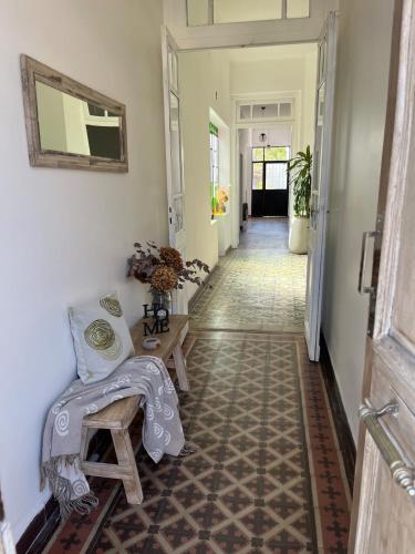 a hallway with a chair and a table in a room at Las Marias in San Fernando del Valle de Catamarca