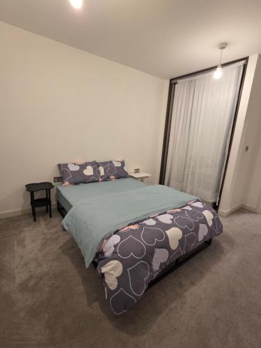 a bedroom with a bed and a large window at City Gateway Apartment - Green Quarter Southall Retreat in Southall