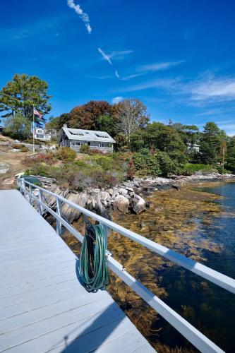a house on the shore of a body of water at Quiet Oceanfront Cottage with Dock in Boothbay Harbor