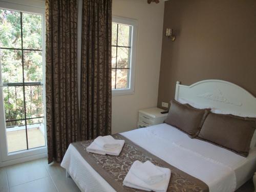 a bedroom with a bed with two towels on it at Enda Boutique Hotel Kalkan in Kalkan