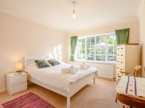 Un dormitorio con una cama blanca y una ventana. en 4 Bed in Bridport 89788, en Corscombe