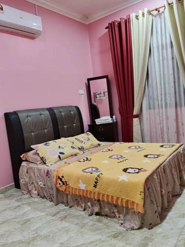 a bedroom with a bed with a yellow blanket on it at Cikgu CTZ Homestay A in Kampung Raja