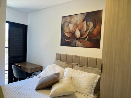 een slaapkamer met een bed met een schilderij aan de muur bij Apartamento Alpha Premium 209 in Ubatuba