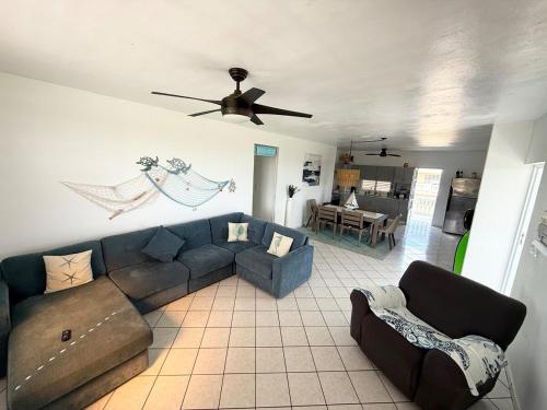 a living room with a couch and a ceiling fan at Enjoy Casa Brisas Del Mar in Maunabo, PR in Maunabo