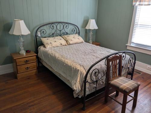 a bedroom with a bed with a chair and two lamps at MinCo Properties WV, Carswell Hollow Overlook in Kimball