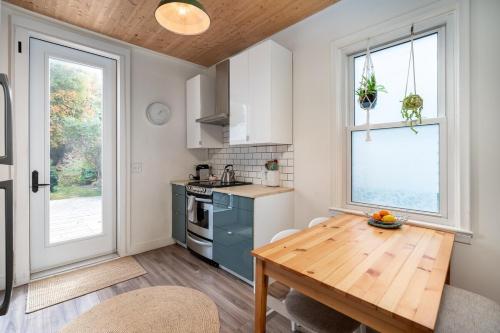 a kitchen with a wooden table and a kitchen with a window at Artistic Picton getaway in Picton