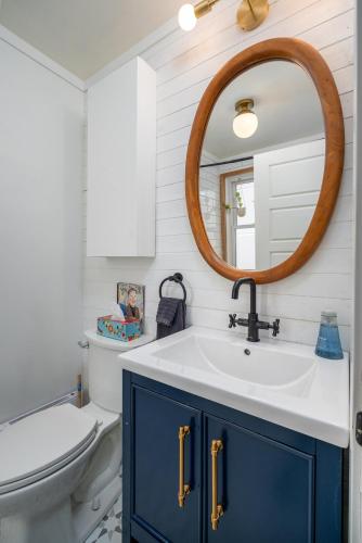 a bathroom with a blue cabinet and a mirror at Artistic Picton getaway in Picton