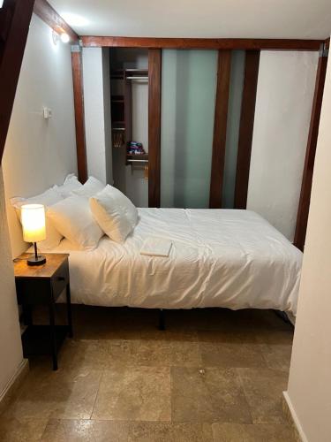 a bedroom with a bed and a table with a lamp at Casa Luna Royale in San Juan