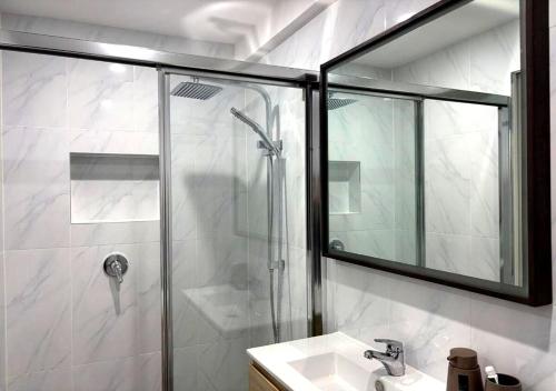 a bathroom with a shower with a sink and a mirror at The Branch by the Basin Family Escape with Sunset Views in St Georges Basin