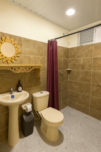 a bathroom with a toilet and a sink and a shower at Hotel Arboleda de Cádiz in Ibagué
