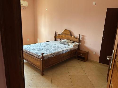 a bedroom with a bed with a wooden frame at 比绍民宿 in Bissau