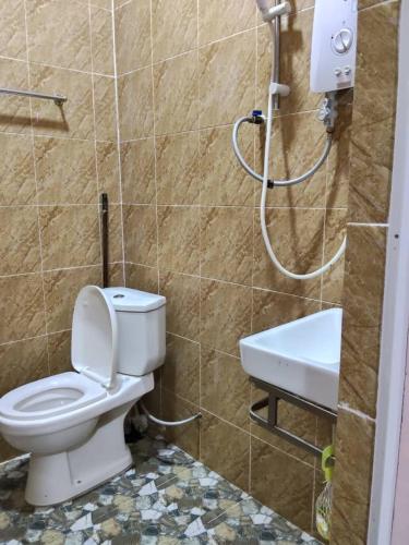 a bathroom with a toilet and a sink at Cikgu CTZ Homestay (B) in Kampong Kubang Bemban