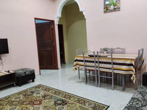 a dining room with a table and chairs in a room at Cikgu CTZ Homestay (B) in Kampong Kubang Bemban