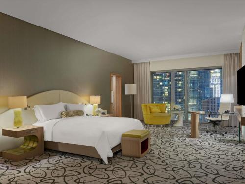 a bedroom with a large bed and a living room at Sofitel Dubai Downtown in Dubai