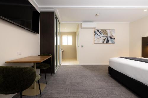 a hotel room with a bed and a desk at Mick O'Sheas in Hackham