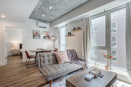 a living room with a couch and a table at Cozy Corner - Modern 1BR in MTL in Montréal