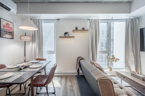 a living room with a dining table and a couch at Cozy Corner - Modern 1BR in MTL in Montréal