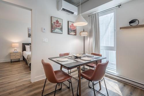 a dining room with a table and chairs and a bedroom at Cozy Corner - Modern 1BR in MTL in Montréal