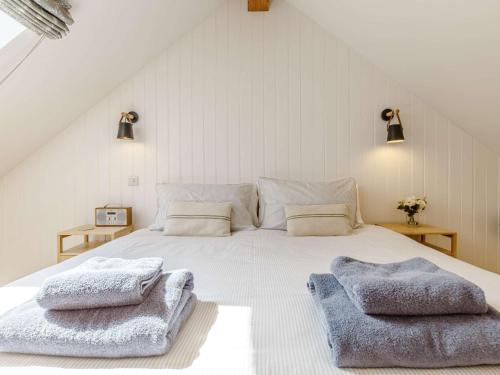 a bedroom with a white bed with two towels on it at 1 Bed in Cadgwith 82496 in Ruan Minor
