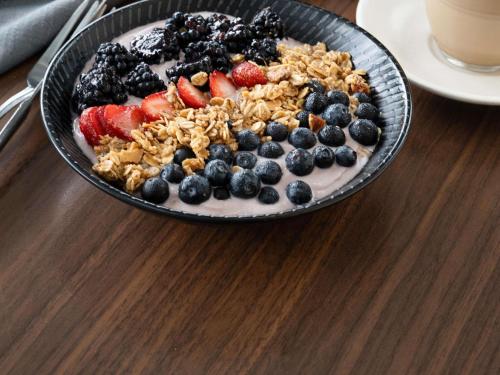 uma tigela de frutas e granola sobre uma mesa em Mercure Melbourne Caroline Springs em Caroline Springs