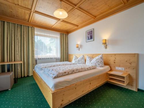 a bedroom with a wooden bed in a room at Ferienhaus Almhof in Gerlosberg