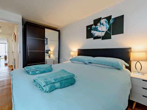 ein Schlafzimmer mit einem großen Bett mit blauen Handtüchern darauf in der Unterkunft 1 Bed in Westward Ho NASEA in Westward Ho