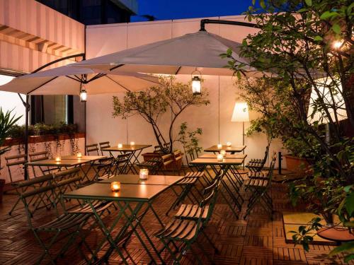 an outdoor patio with tables and chairs with candles at Mercure Milano Agrate Brianza in Agrate Brianza