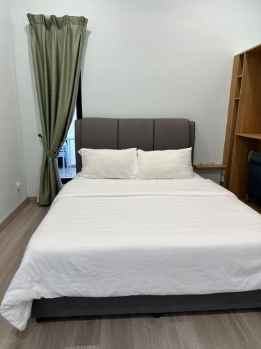 a large bed with white sheets in a bedroom at Rumah Tamu Sonata in Seremban