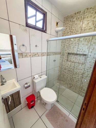 a bathroom with a toilet and a glass shower at Residencial dos Ipês in Itacaré