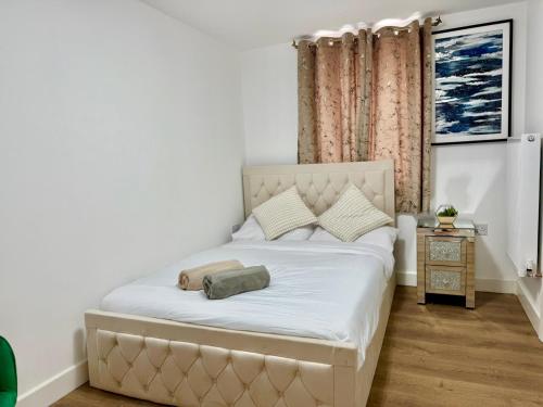 a bedroom with a large bed with white sheets at DSK Residencia in Maidstone