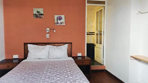 a bedroom with a bed with an orange wall at La Casona de Jerusalen in Arequipa