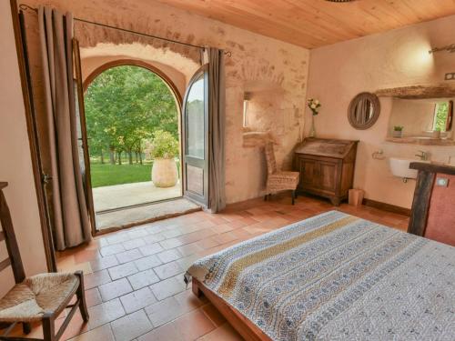 Un dormitorio con una cama y una ventana y un escritorio. en La Roque Haute, en Salles-de-Belvès