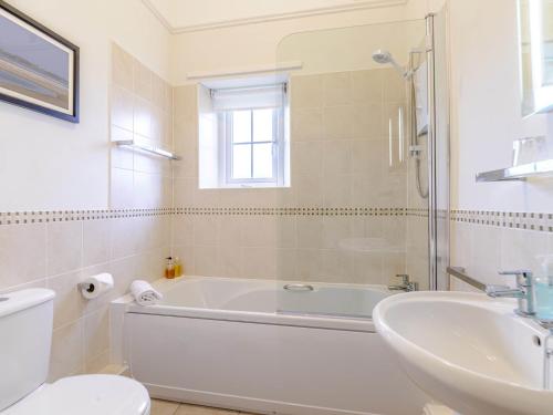 a white bathroom with a tub and a sink at 2 Bed in Newton-by-the-Sea 80482 in Newton by the Sea