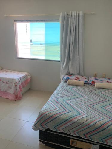 a small bedroom with a bed and a window at pousada Requenguela in Icapuí