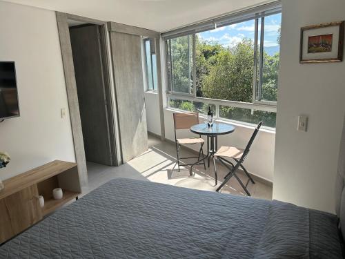 a bedroom with a bed and a table and a window at Apartamento Living in La Ceja