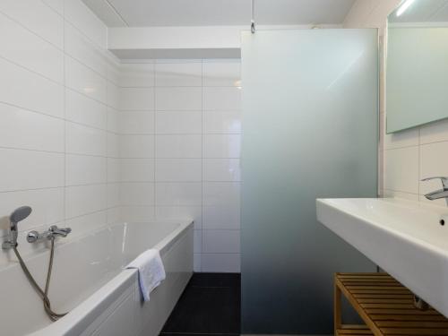 a white bathroom with a tub and a sink at Assum Great in Uitgeest
