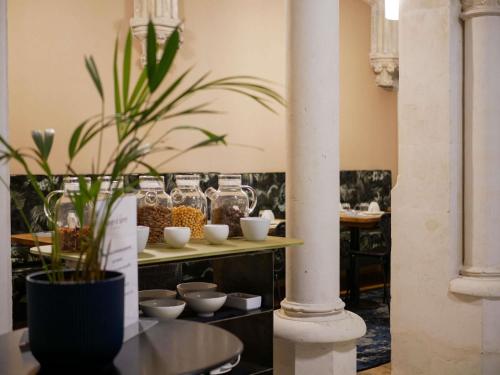 um quarto com uma mesa com um vaso de plantas em Mercure Poitiers Centre em Poitiers