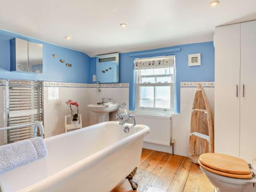baño con paredes azules, bañera y aseo en 2 Bed in Portland 91468, en Castletown