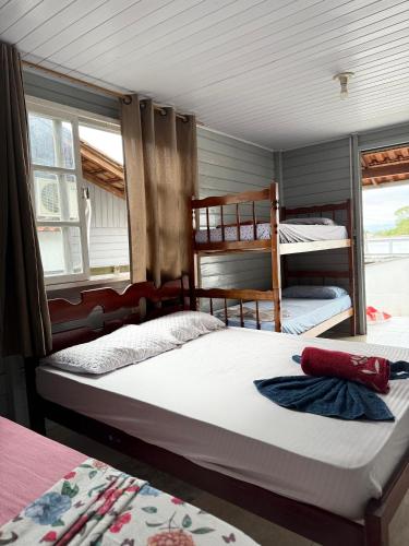 a bedroom with two bunk beds and two windows at Da Silva Chalé in Santa Lídia