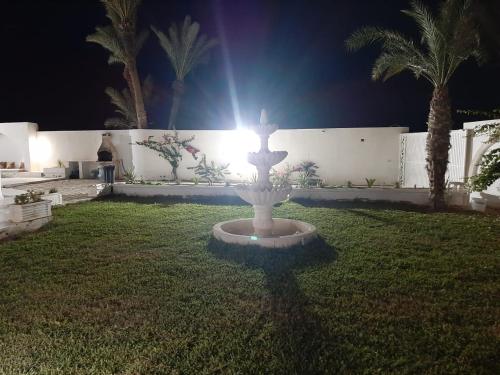 a fountain in the middle of a yard at night at Villa Narjess in Taguermess