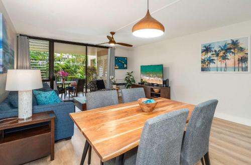 a dining room and living room with a table and chairs at Charming Beachside Garden Vistas in Wailea