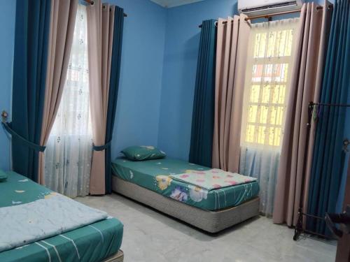 Kampong Kubang BembanにあるCikgu CTZ Homestay (C)のベッドが2つと窓が2つある寝室