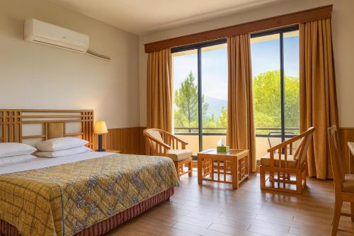 a hotel room with a bed and a large window at Rock City Resort in Mingāora