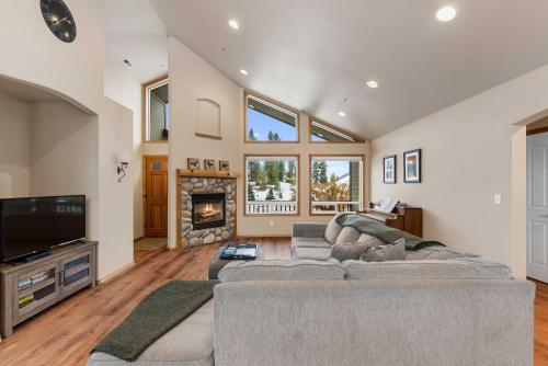 a living room with a couch and a tv and a fireplace at Cairn Cottage - Alice Lodging in Leavenworth
